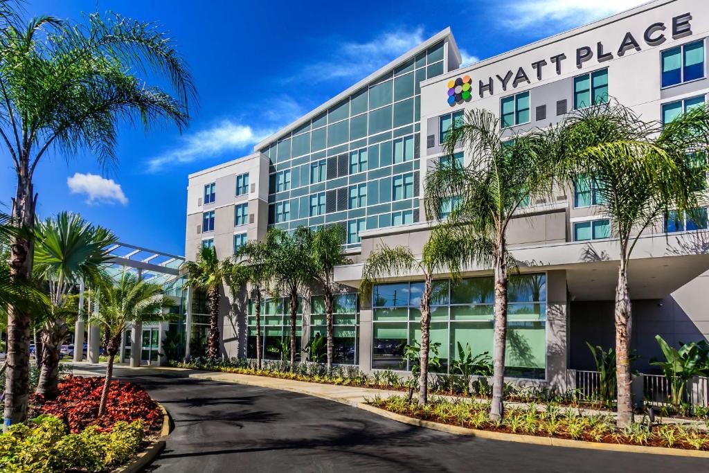 ein Bürogebäude mit Palmen davor in der Unterkunft Hyatt Place Manati in Manati