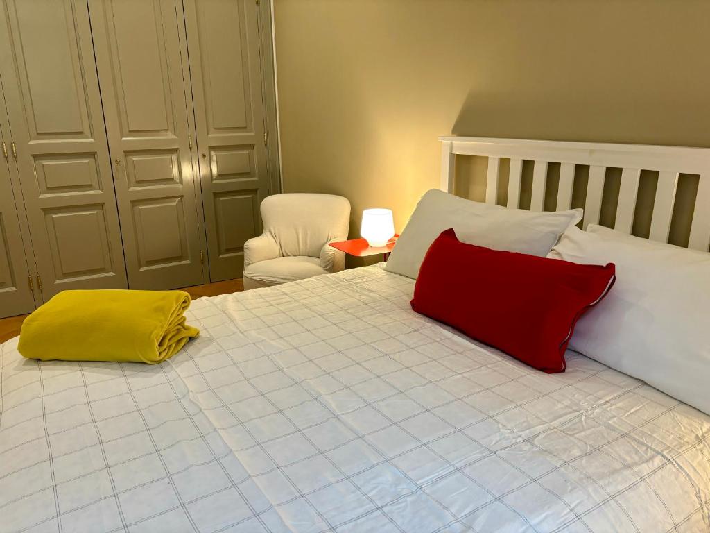una camera con un letto con due cuscini rossi e gialli di NAPOLIFOREVER Chiaia APARTMENT a Napoli