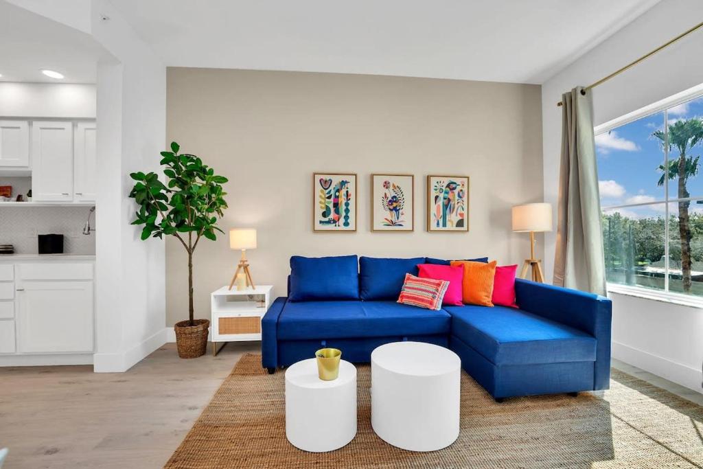 奧蘭多的住宿－Casa Magical 1mile to Disney，客厅里配有带色彩缤纷枕头的蓝色沙发