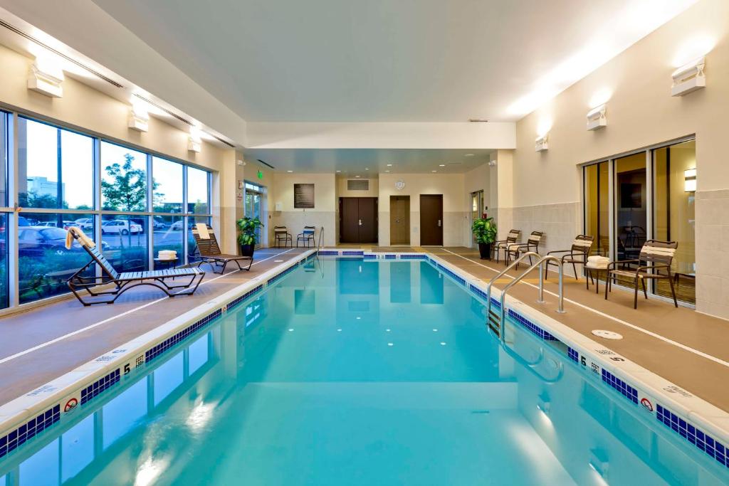 a large swimming pool with blue water in a building at Hyatt Place Garden City in Garden City
