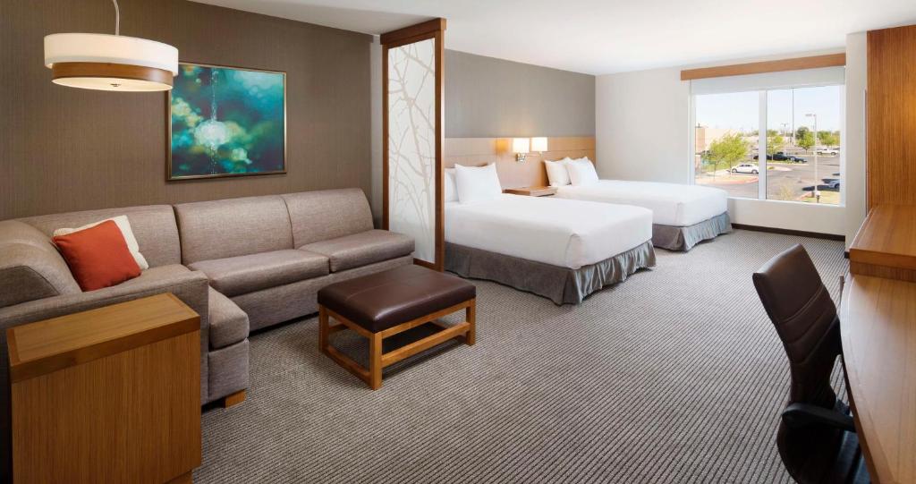 ein Hotelzimmer mit einem Sofa und 2 Betten in der Unterkunft Hyatt Place Lubbock in Lubbock