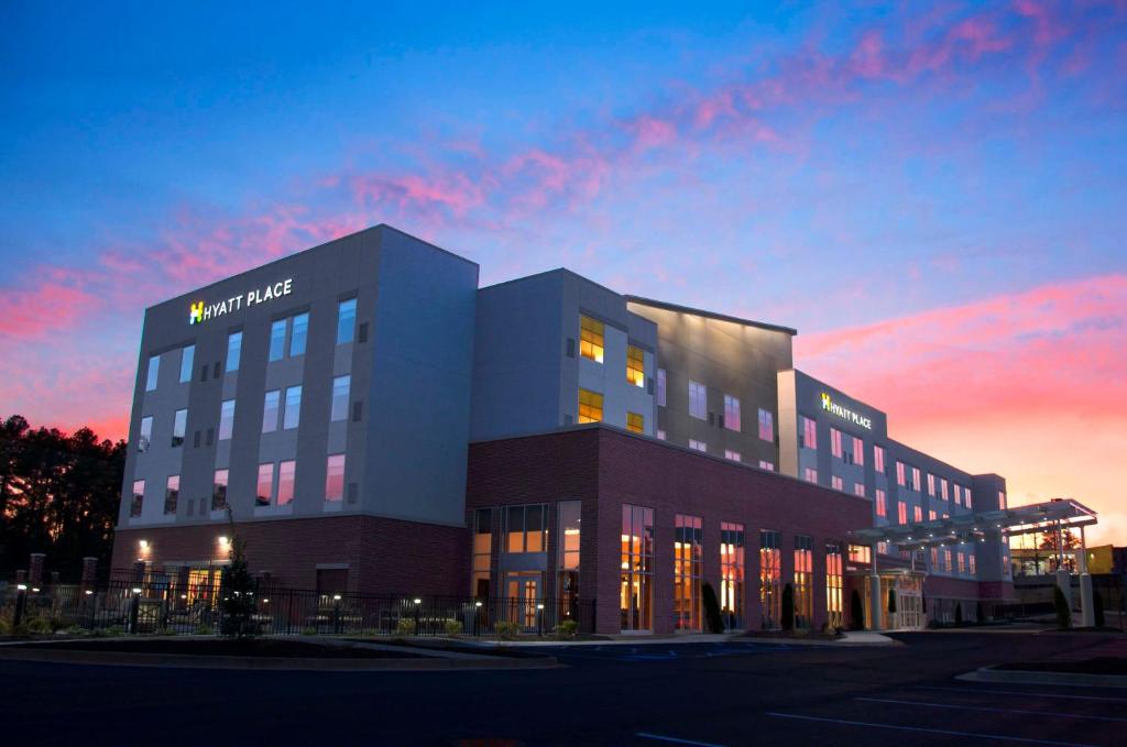 a large office building with a sunset in the background at Hyatt Place Augusta in Augusta