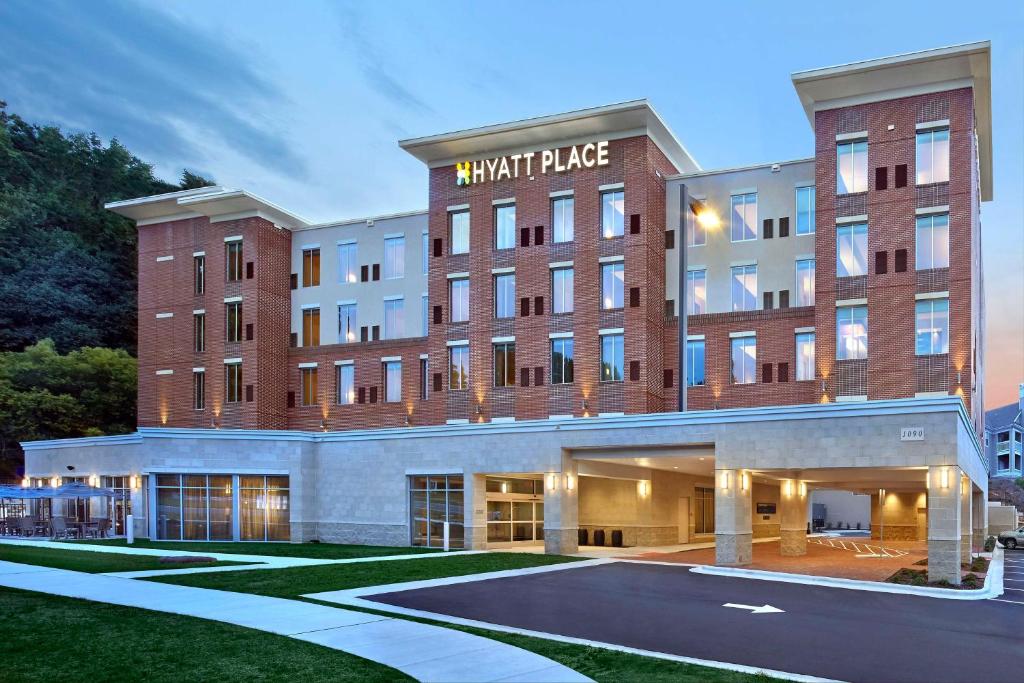 een hotelgebouw met een parkeerplaats ervoor bij Hyatt Place Chapel Hill in Chapel Hill