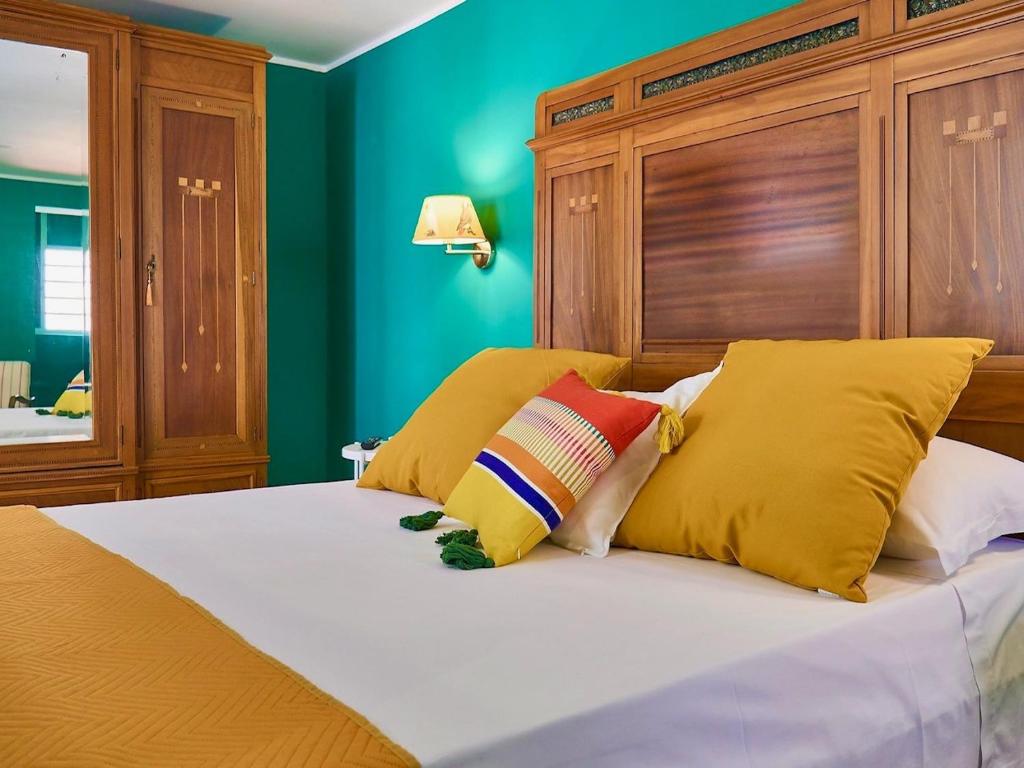 um quarto com uma cama com almofadas amarelas e vermelhas em Qurchiti em Capo dʼOrlando