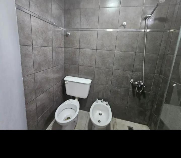 a small bathroom with a toilet and a shower at Apartamentos Luz in Mendoza