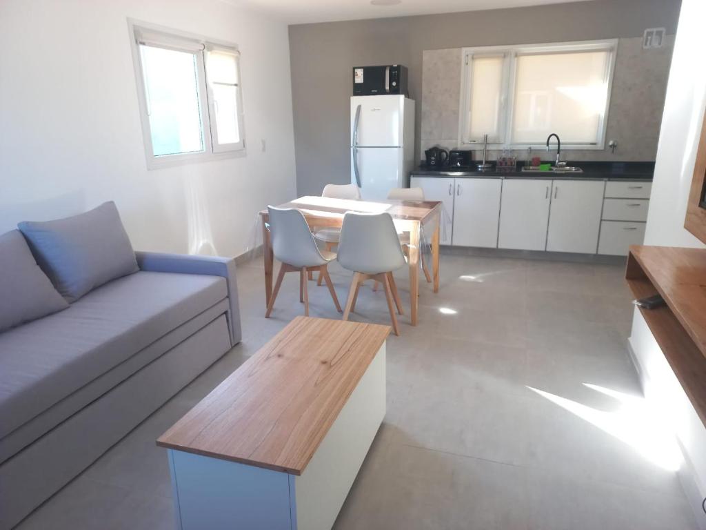 a living room with a couch and a table and a kitchen at Villa las Marias in San Carlos de Bariloche