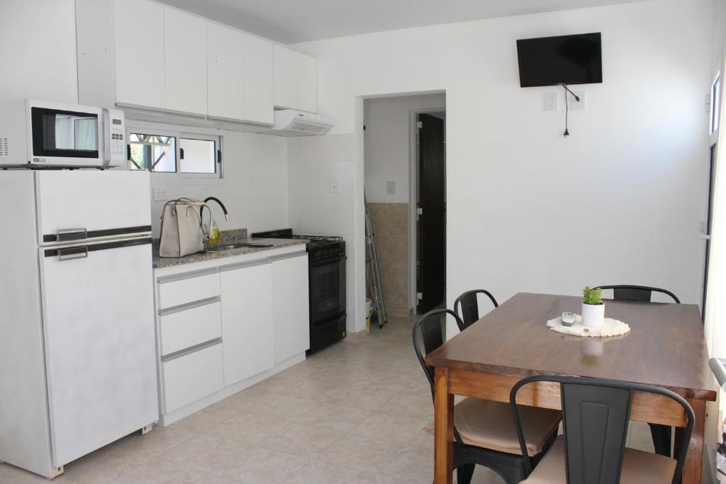 uma cozinha com electrodomésticos brancos e uma mesa com cadeiras em Alojamiento en Chajarí em Chajarí
