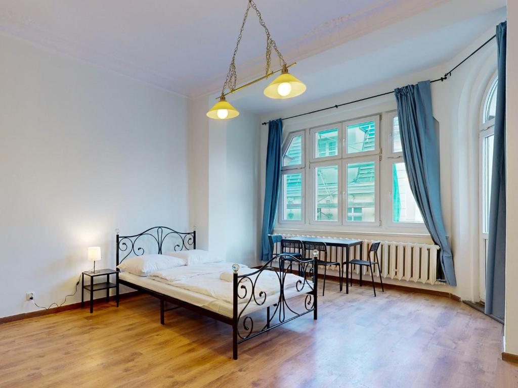 1 dormitorio con 1 cama, mesa y sillas en roomspoznan pl - Apartamenty i Pokoje Półwiejska 20 - 24h self check-in, en Poznan