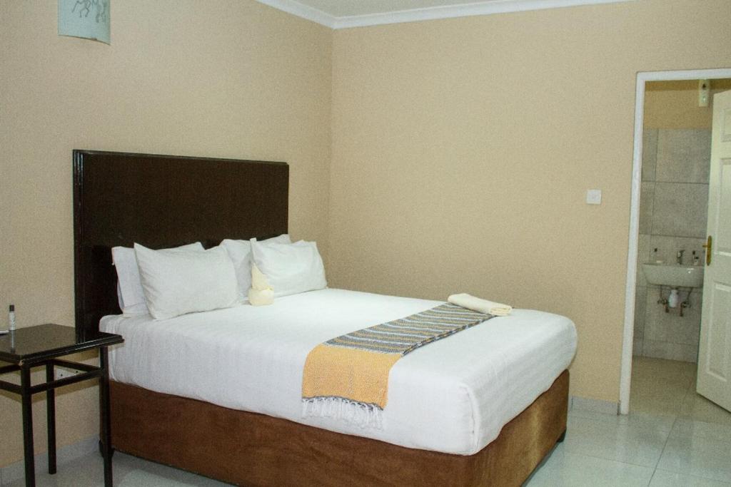 ein Schlafzimmer mit einem großen Bett in einem Zimmer in der Unterkunft Kamanga Safari Lodge in Maun