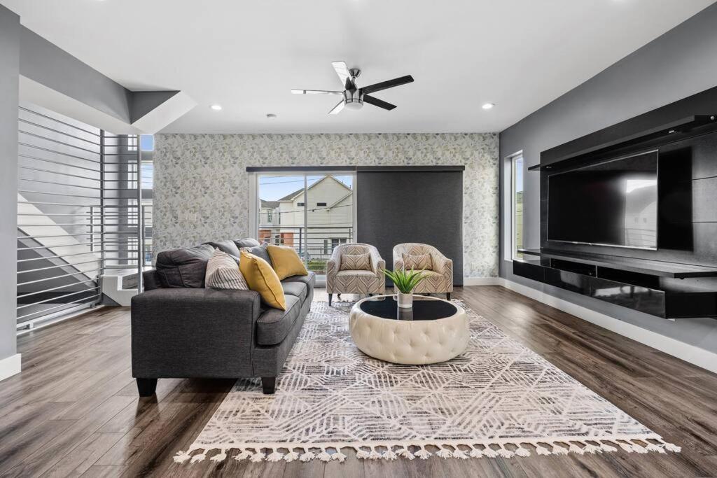 uma sala de estar com um sofá e uma televisão em 15 Min From Downtown Spacious Luxury Home em Houston