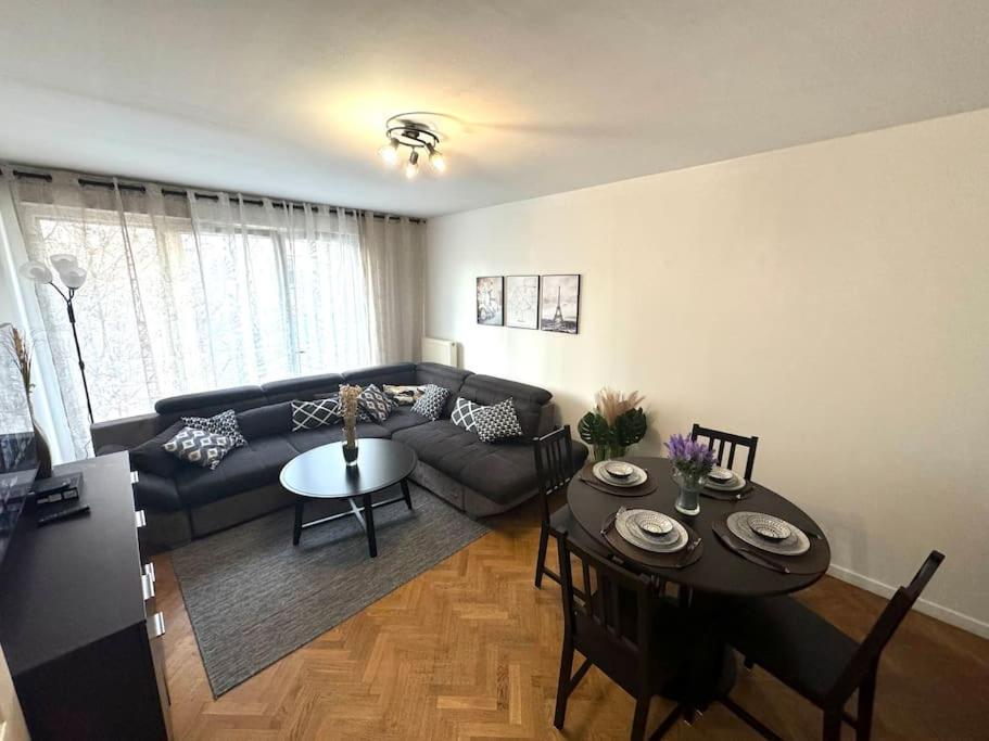 - un salon avec un canapé et une table dans l'établissement Charmant appartement aux portes de Paris, à Asnières-sur-Seine