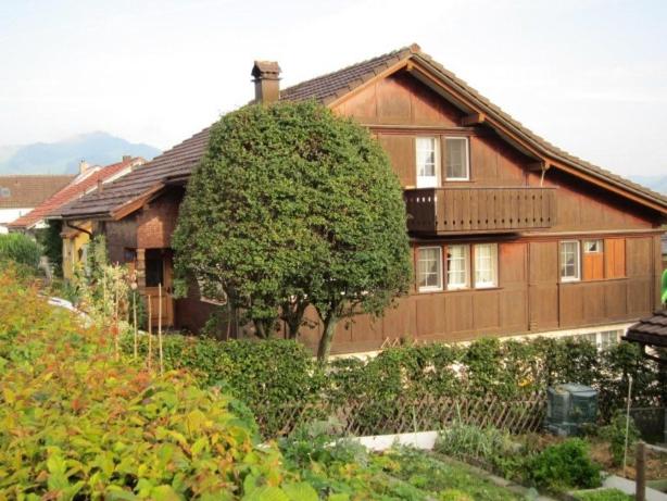 ein großes Haus mit einem Baum davor in der Unterkunft Ferienwohnung Inauen in Appenzell