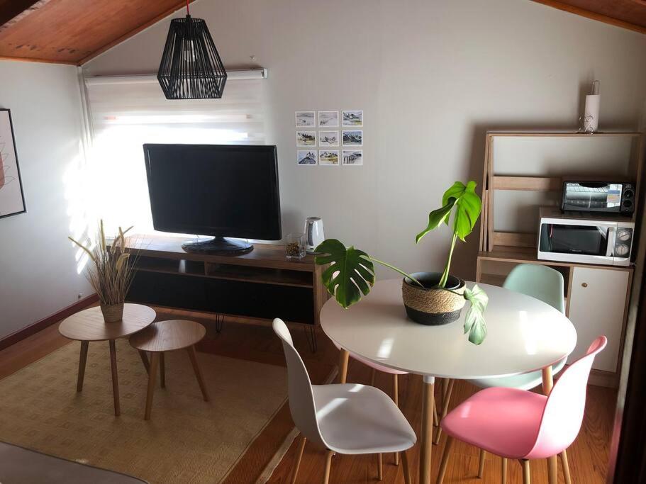 sala de estar con mesa, sillas y TV en Departamento cerro de la cruz en Punta Arenas