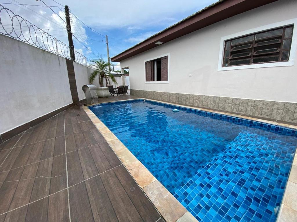 una piscina en el patio trasero de una casa en Beach House, en Mongaguá