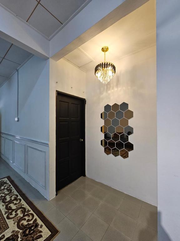 a hallway with a black door and a chandelier at Ruhani Homestay 1 KB - 3 Bedroom Fully Airconditioned in Kota Bharu