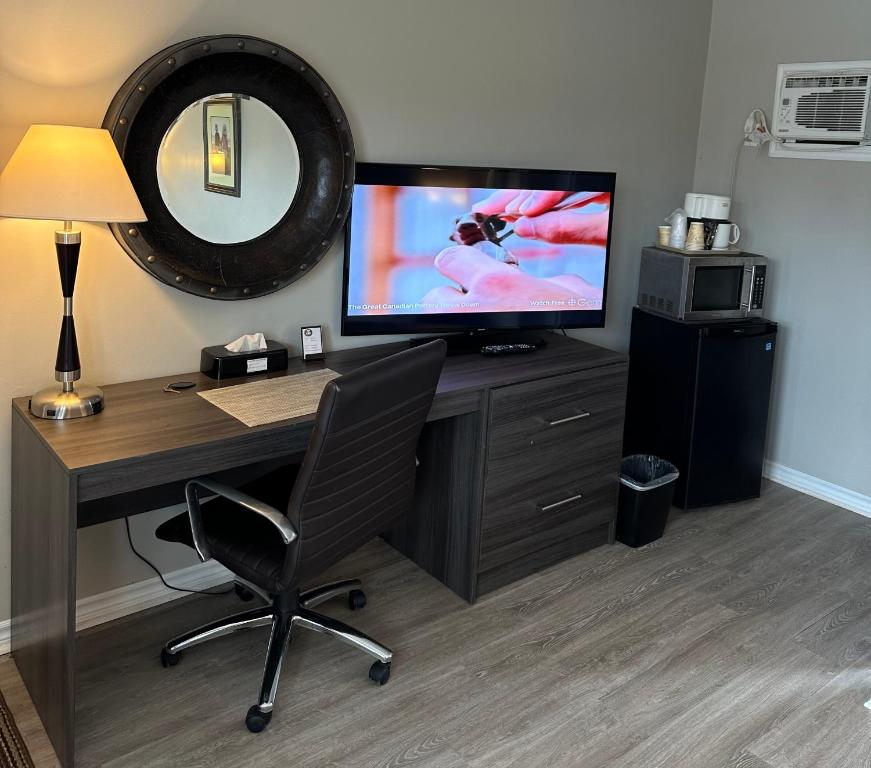 una oficina con escritorio, TV y silla en Lakeview Motel & Cottage, en Kincardine