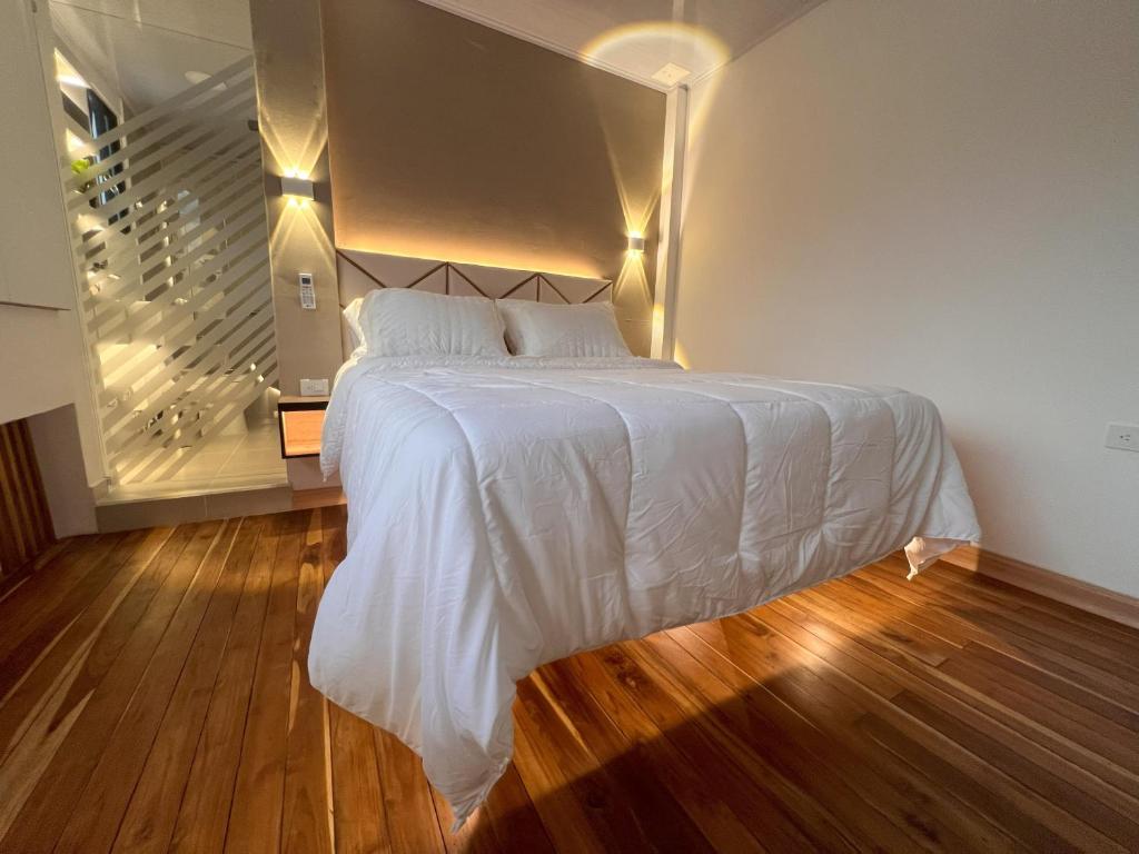 - une chambre avec un lit blanc et un escalier dans l'établissement 'SELECT' Medellin, à Medellín