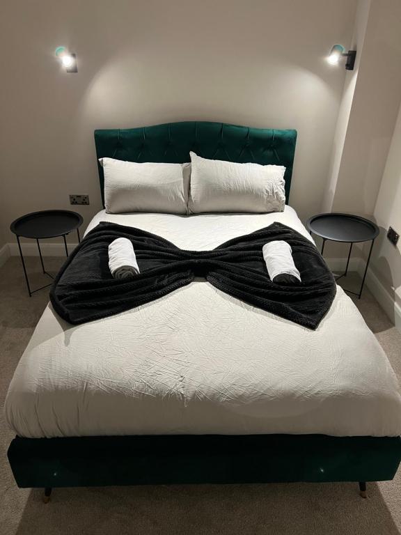 un letto con un farfallino nero sopra di Cozy Intimate Apartment - Leeds a Leeds