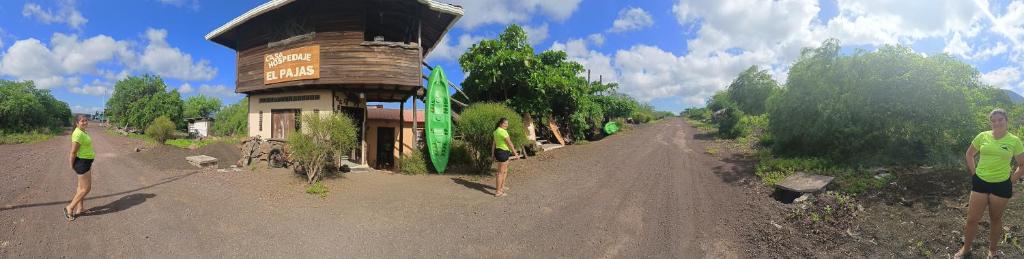 two people standing on a dirt road next to a building at El Pajas in Puerto Velasco Ibarra
