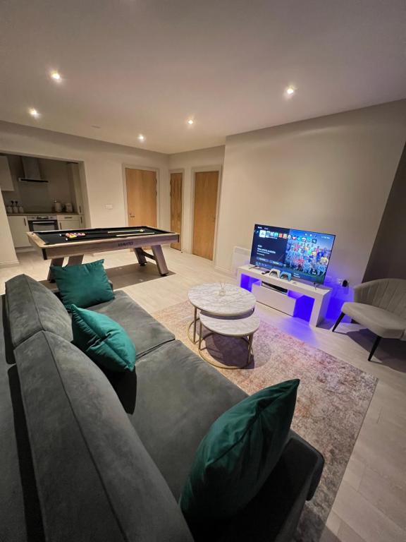 a living room with a couch and a pool table at Spacious Modern Apartment - Leeds City Centre in Leeds