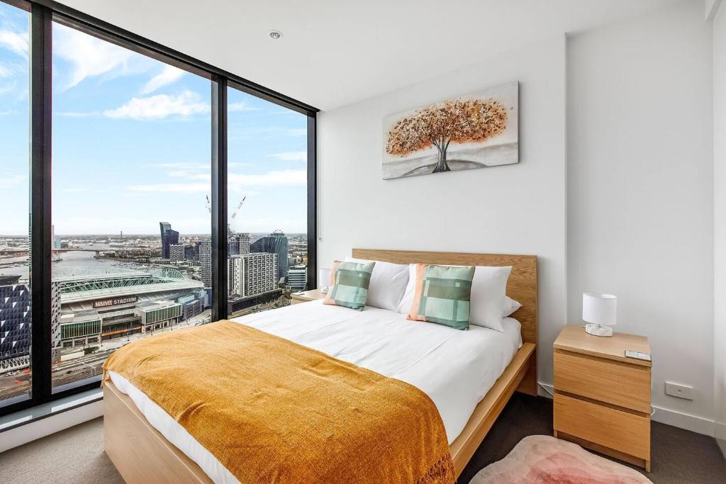 a bedroom with a bed and a large window at The Spencer Suite - Cityscape Panorama with Pool in Melbourne