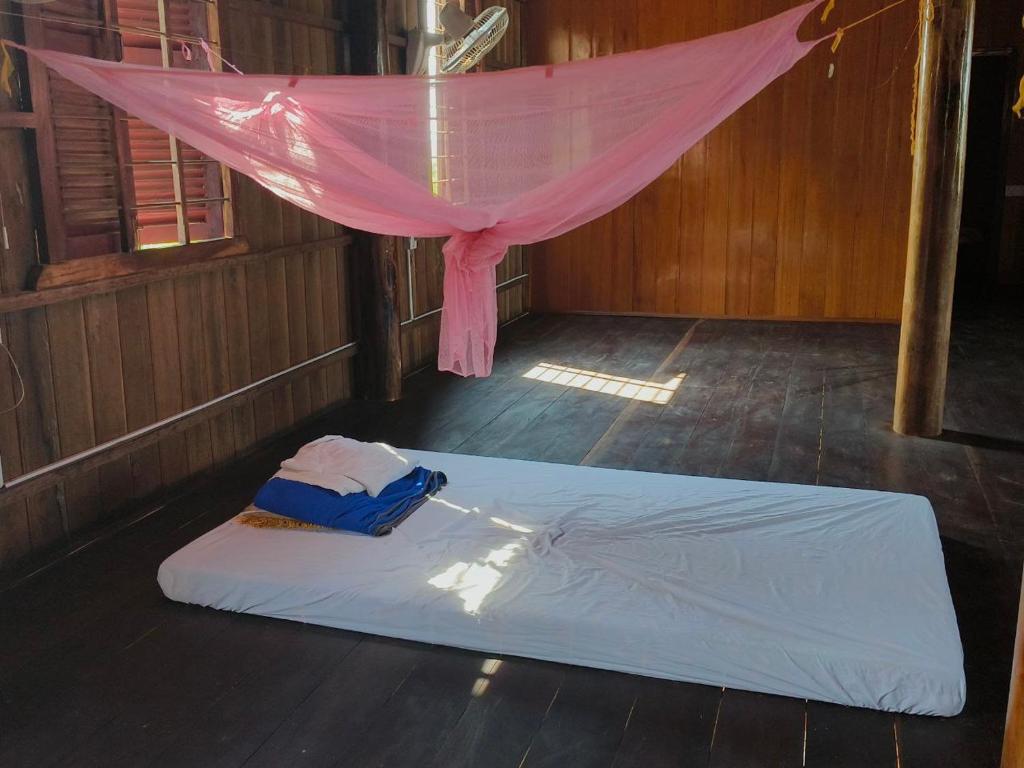 Cama en habitación con dosel rosa en Melop Koki Homestay 7 en Krong Kracheh