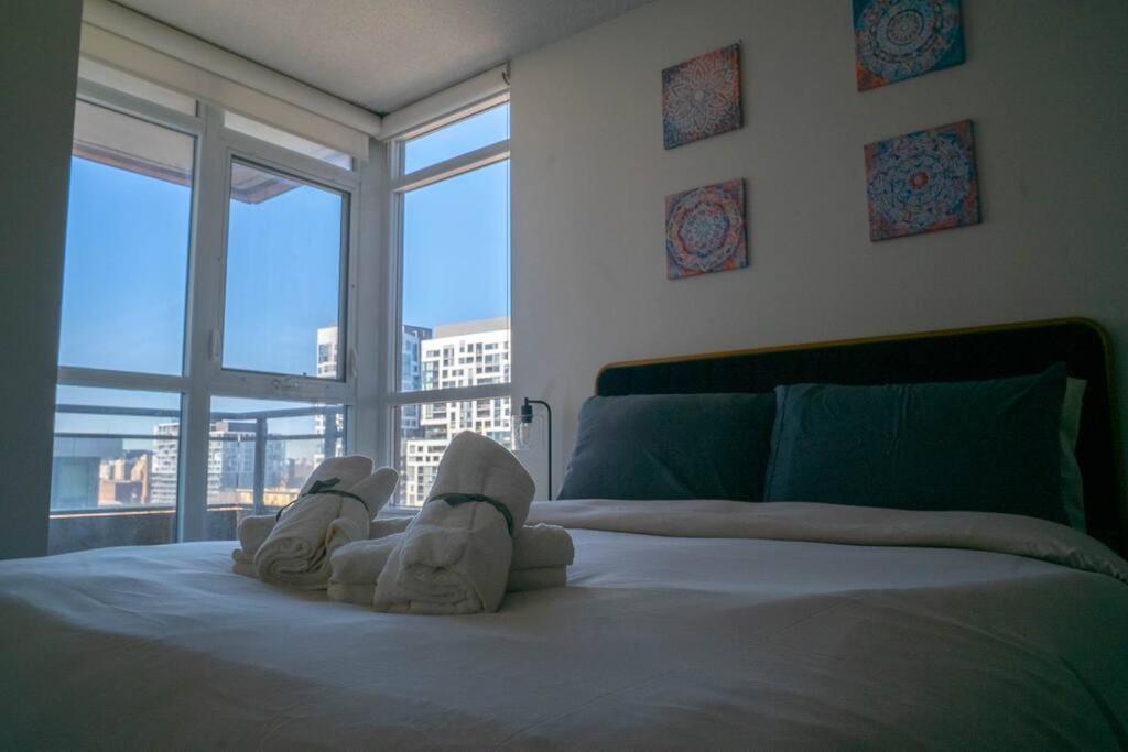 - une chambre avec un lit et une paire de serviettes dans l'établissement Beautiful and Central 3 Bedroom Condo with Parking, à Toronto