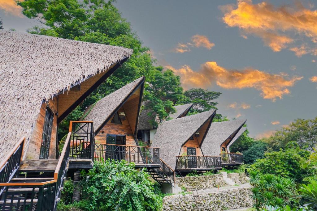 a row of cottages with thatched roofs at NAWA Wellness in Calatagan