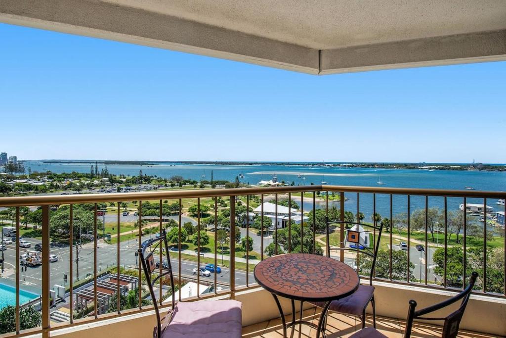 a balcony with a table and chairs and a view of the ocean at Oceanview Delight in Gold Coast
