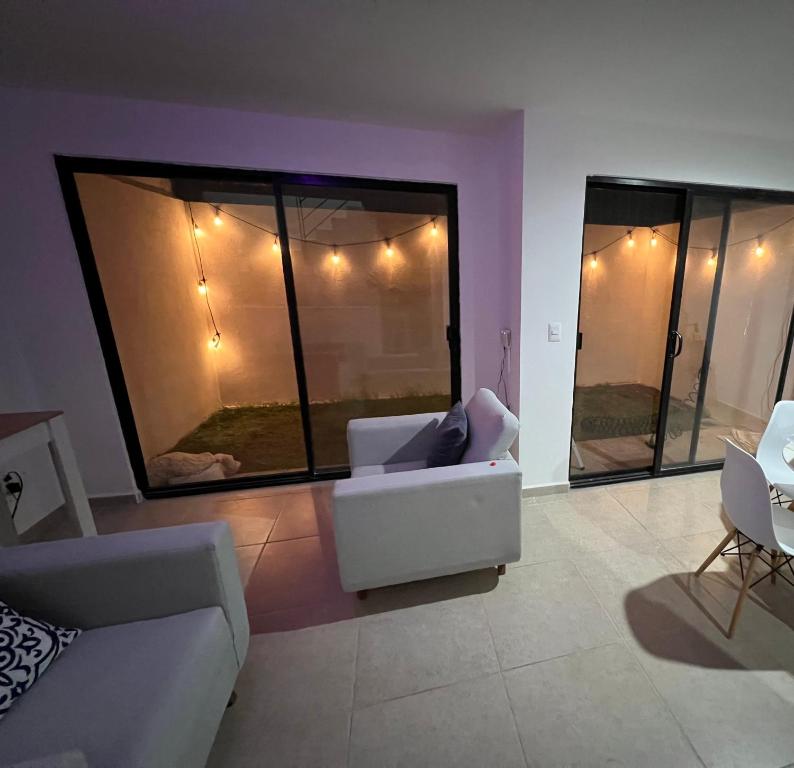 Habitación en Querétaro Capital في Tlacote el Bajo: غرفة معيشة بها أريكة بيضاء وبعض الكراسي