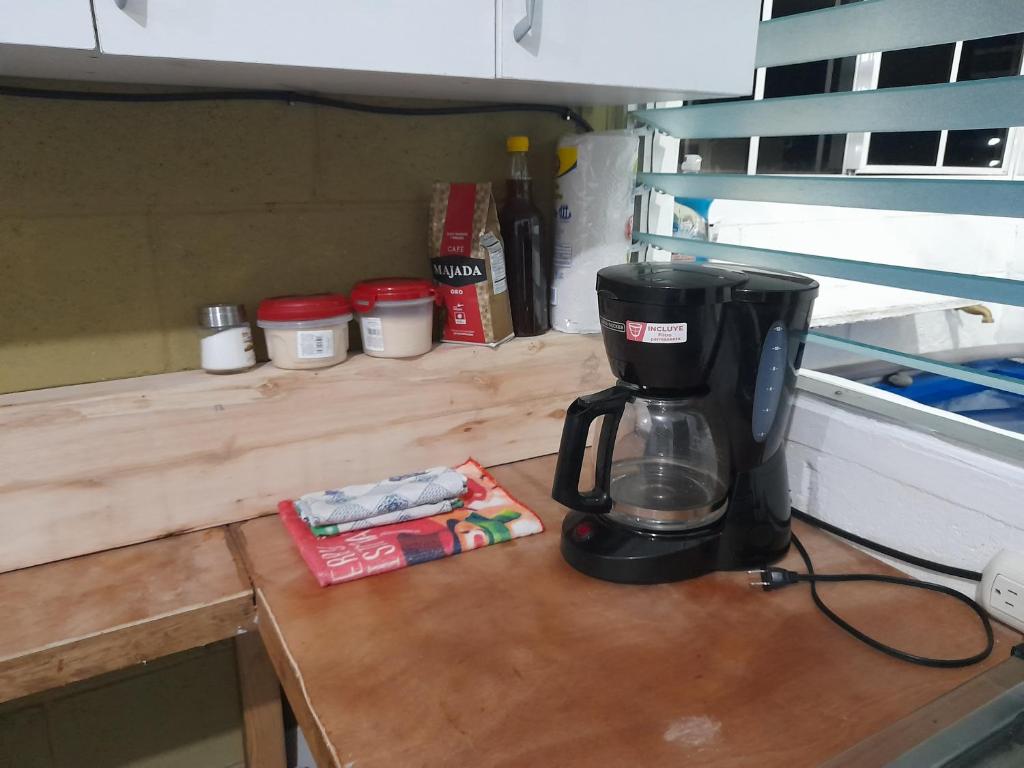 una macchina da caffè seduta su un ripiano in legno di Apartamento 33 a Santa Ana