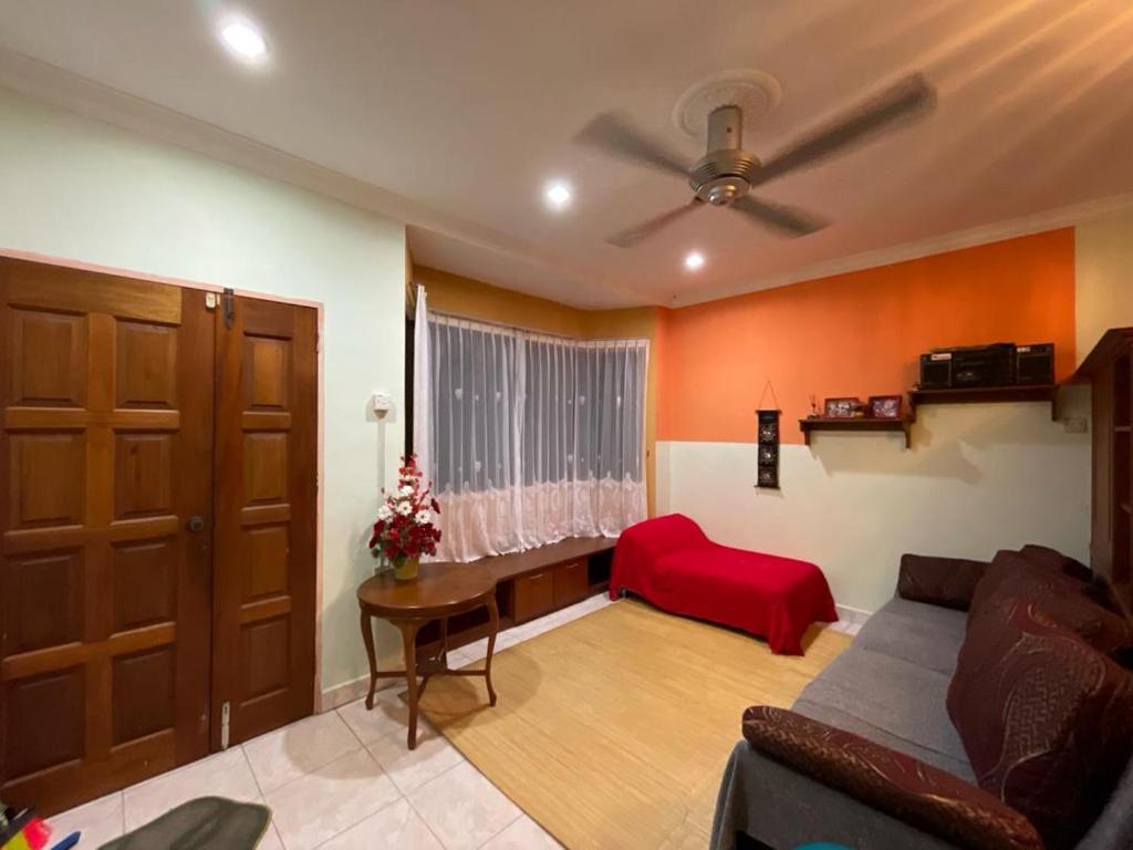 ein Wohnzimmer mit einem Sofa und einer roten Decke in der Unterkunft Venice 142 Homestay in Lumut