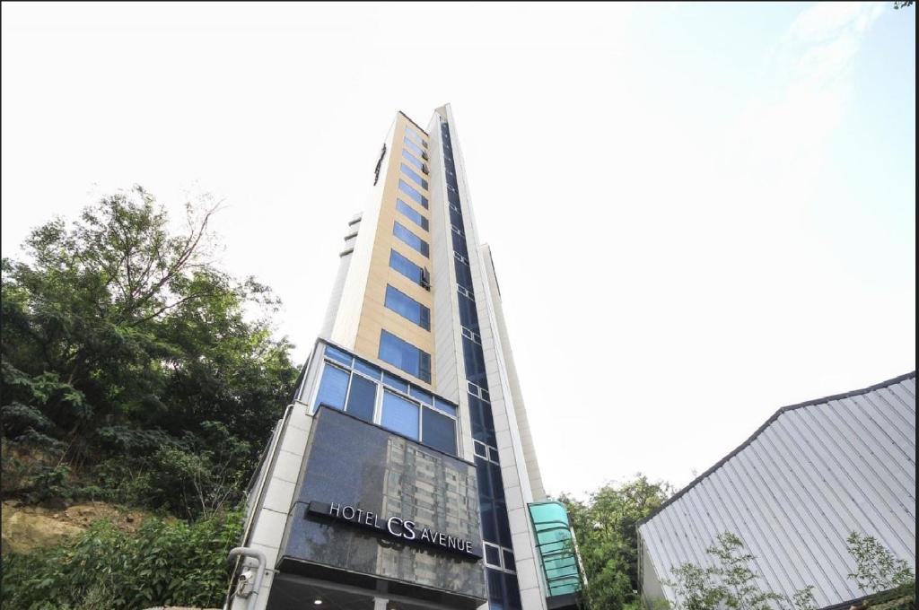 Un edificio alto con un cartel. en CS Avenue Tourist Hotel, en Seúl