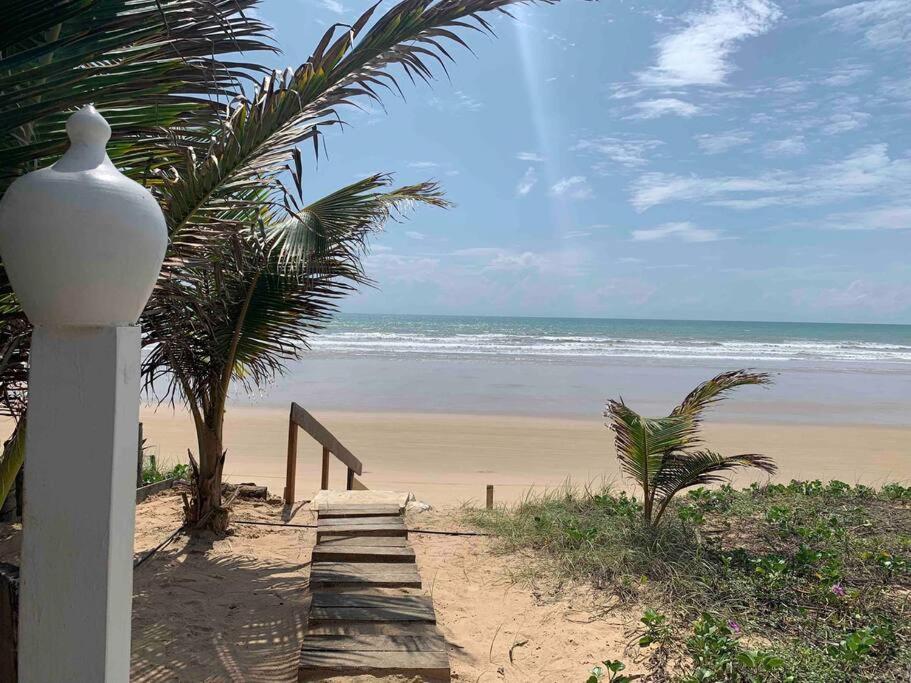 a stairway leading to a beach with the ocean at Bela casa de praia beira mar in Feliz Deserto