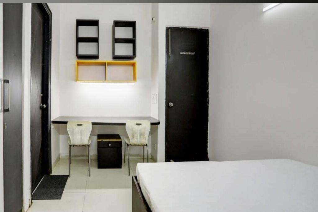 - une chambre avec une table, deux chaises et un lit dans l'établissement Ashiyana Homes, à New Delhi