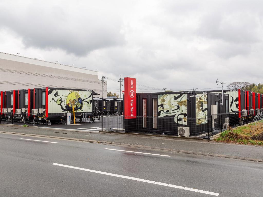 a row of train cars parked on the side of a road at HOTEL R9 The Yard Kikuchi in Kikuchi