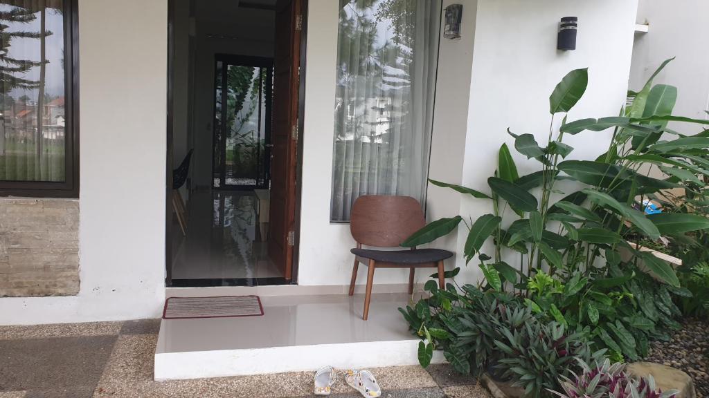 uma cadeira sentada no alpendre da frente de uma casa em Vila Adinda Syariah C-4 Bukit Gardenia Resort em Garut