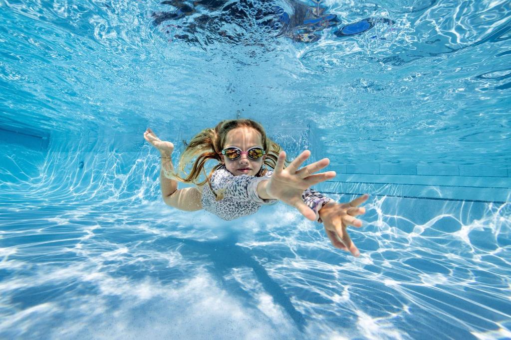 una niña nadando en una piscina en Hot Water Beach TOP 10 Holiday Park en Hotwater Beach