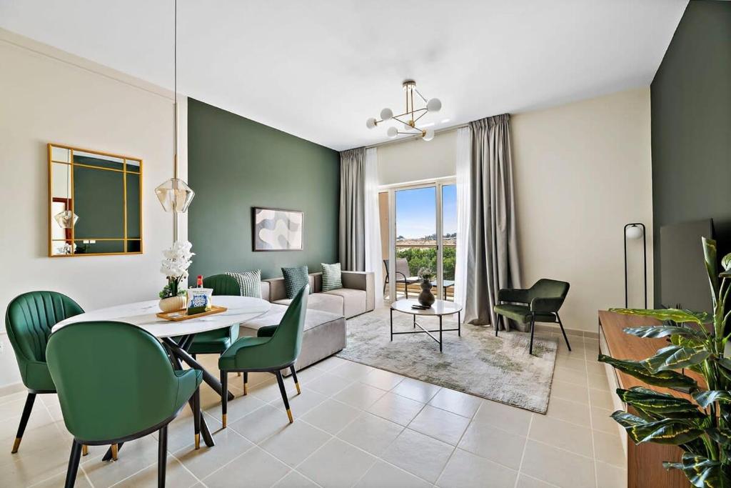 a living room with a table and green chairs at Silkhaus The Greens neighborhood newly furnished 1BDR in Dubai