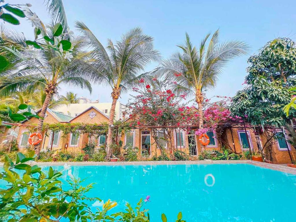 une maison avec des palmiers et une piscine dans l'établissement Mui Ne Sunlight Villa, à Mui Ne