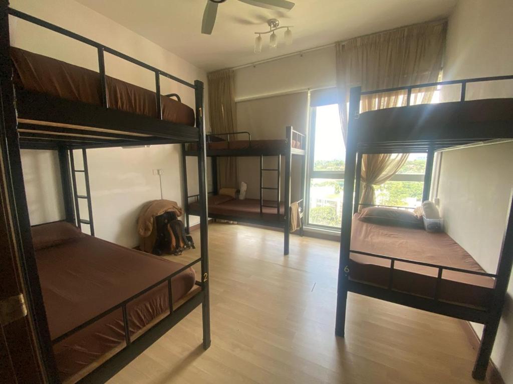 Regalia Exclusive Hostel في كوالالمبور: غرفة بها ثلاثة أسرة بطابقين وممر