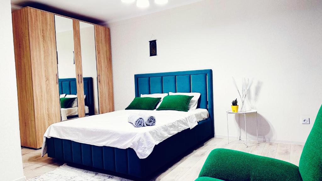 um quarto com uma cama grande e almofadas verdes em Ардк em Oral