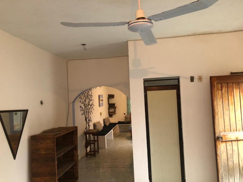 a living room with a ceiling fan and a hallway at Bungalo en Tecolutla in Tecolutla