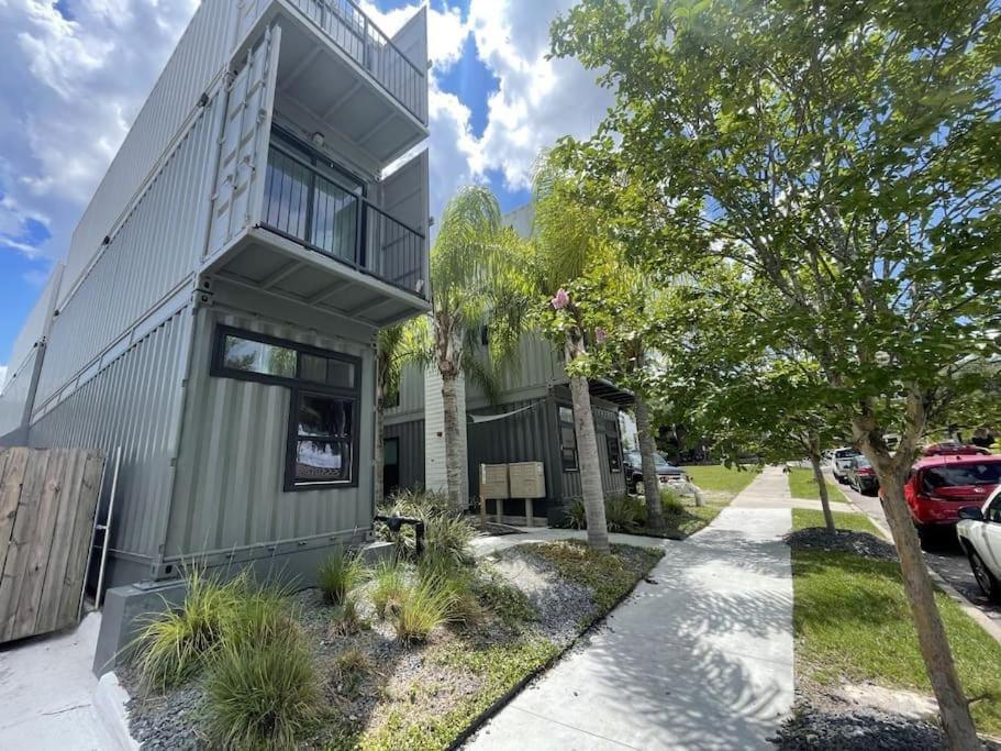 ein grünes Haus mit einem Baum neben einem Bürgersteig in der Unterkunft Hip Container APT - 5 Min Walk to TIAA Bank in Jacksonville