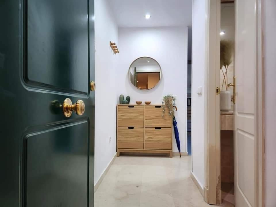 een badkamer met een spiegel en een houten dressoir bij Apartment Beachfront Accommodation in Estepona