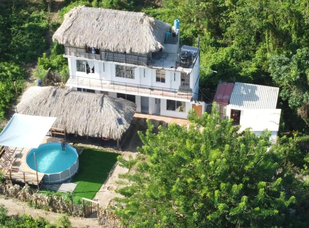 an aerial view of a house with a thatch roof at Islafuerteparadise in Puerto Limón