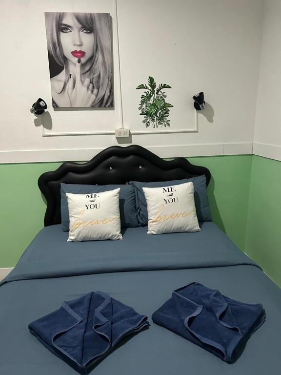 1 cama con edredón azul y 2 almohadas en Labella samet guesthouse en Ko Samed