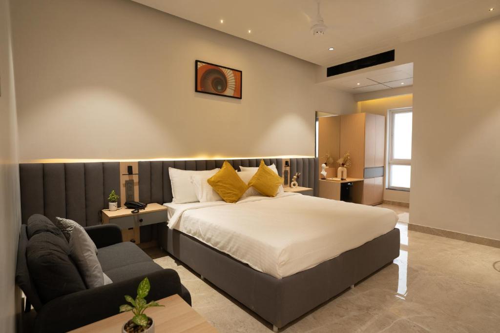 a bedroom with a bed and a couch at Hotel Kyzen Hi Tech City in Hyderabad