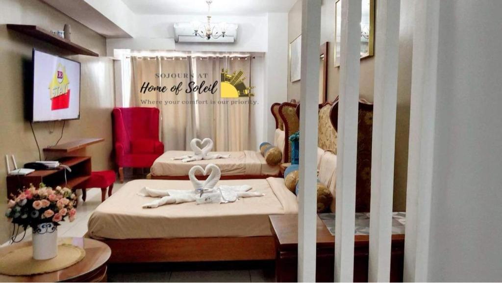 1 dormitorio con 2 camas, mesa y silla en Home Of Soleil At SM Wind Tagaytay, en Tagaytay