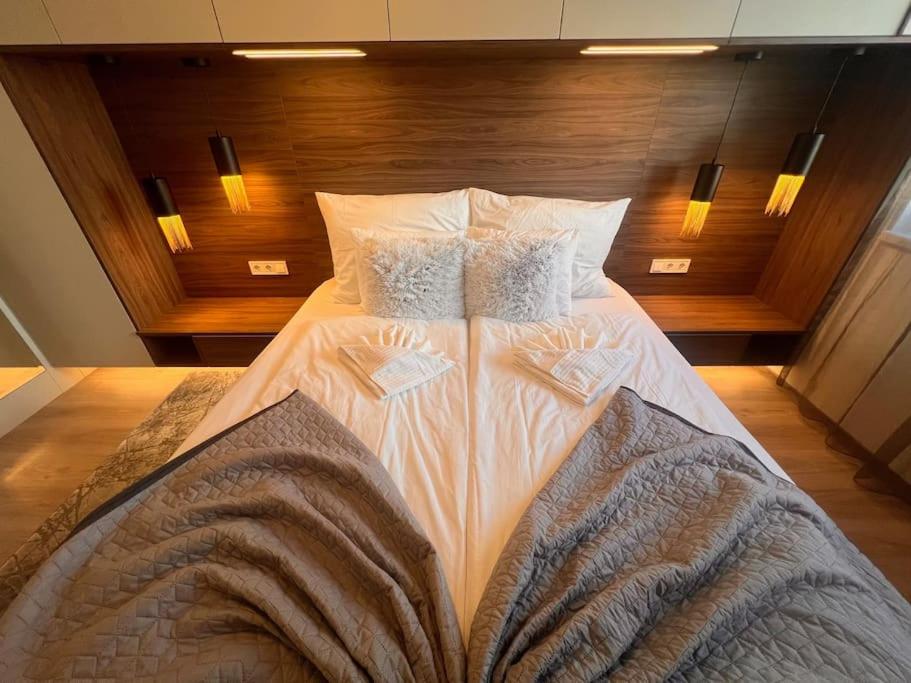 1 cama grande con sábanas y almohadas blancas en Karzo Property LK 206, en Budapest